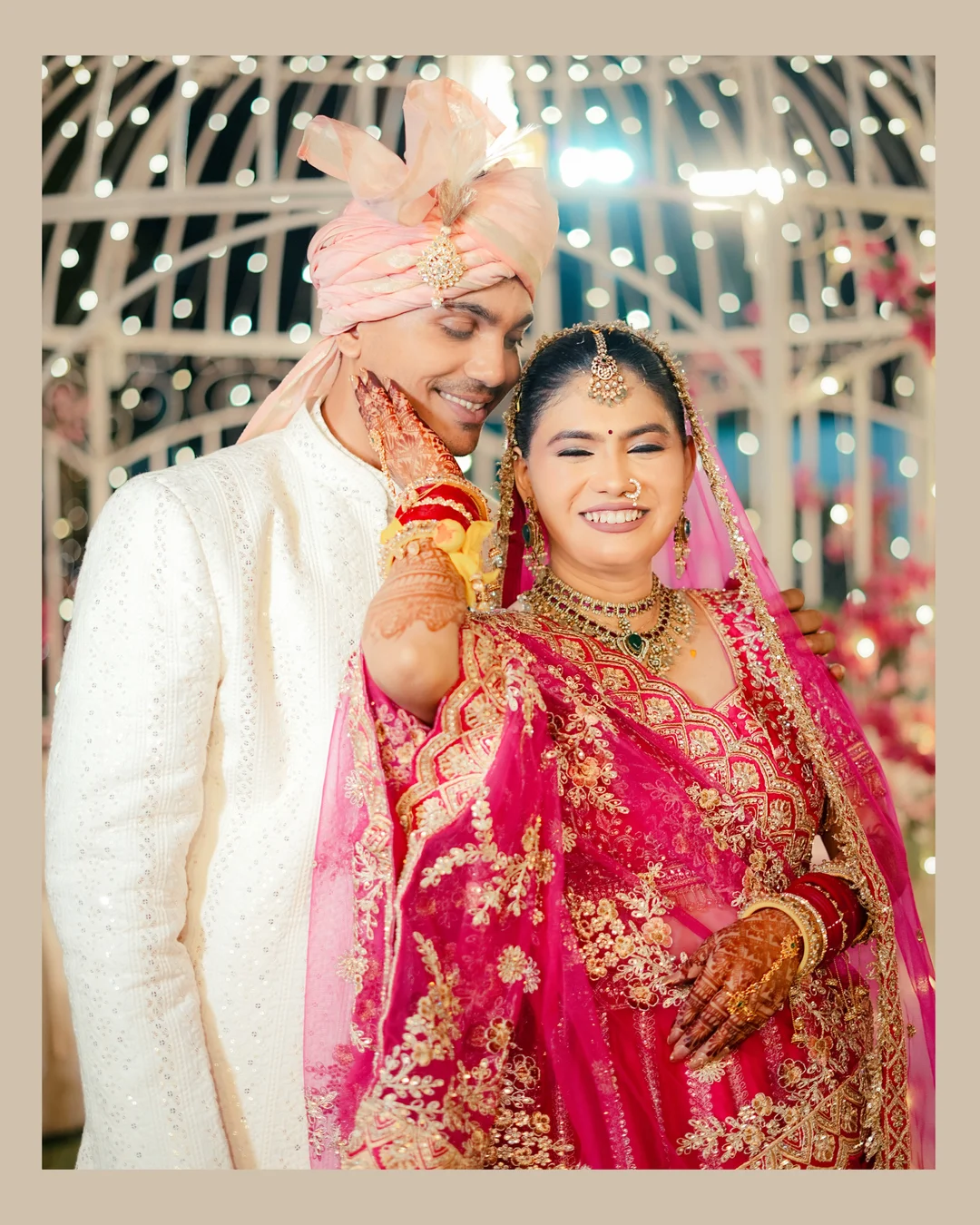 Groom in a pink safa holding his bride close