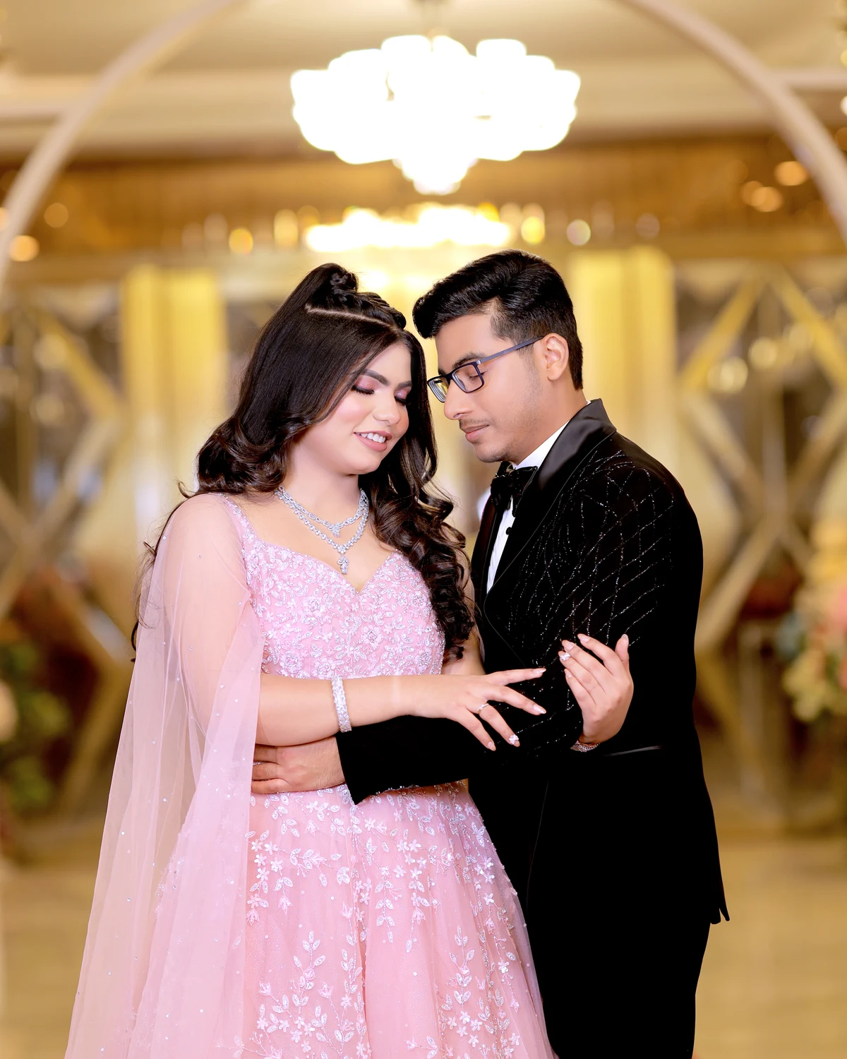 Couple holding each other under soft pink lights
