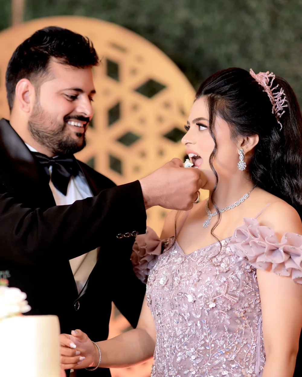 Groom feeding his laughing bride a bite of wedding cake